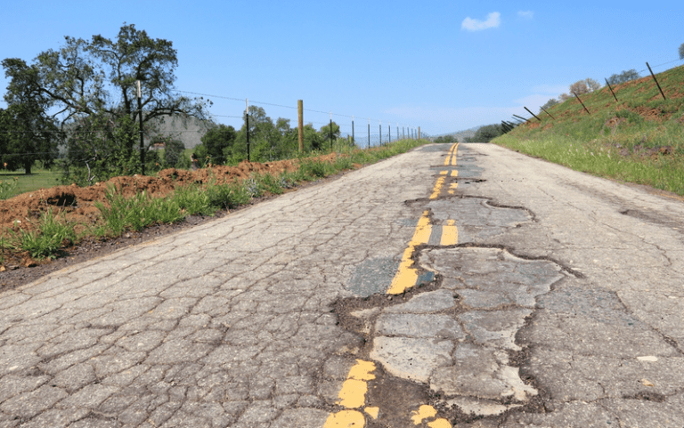 cracked asphalt blacktop with potholes and patches