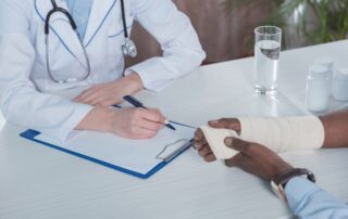 Doctor sitting at a table with a patient, assessing injury for disability claim