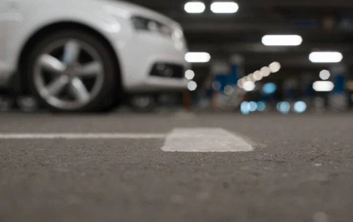 Parking lot asphalt with white line and blurred car, illustrating Louisiana parking lot accident liability and fault issues
