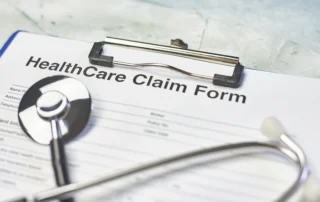 Healthcare claim form and stethoscope on clipboard, illustrating Louisiana medical liens on injury treatment and settlement costs.